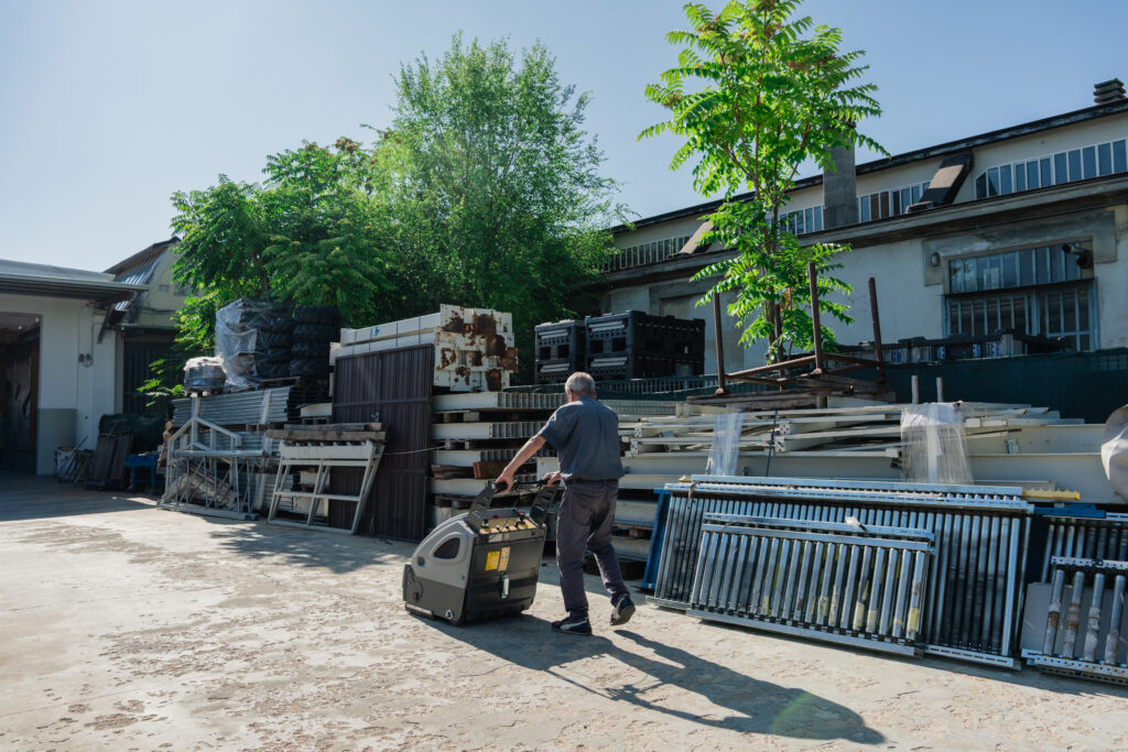 Operaio che movimenta materiale in ferro nel piazzale della carpenteria