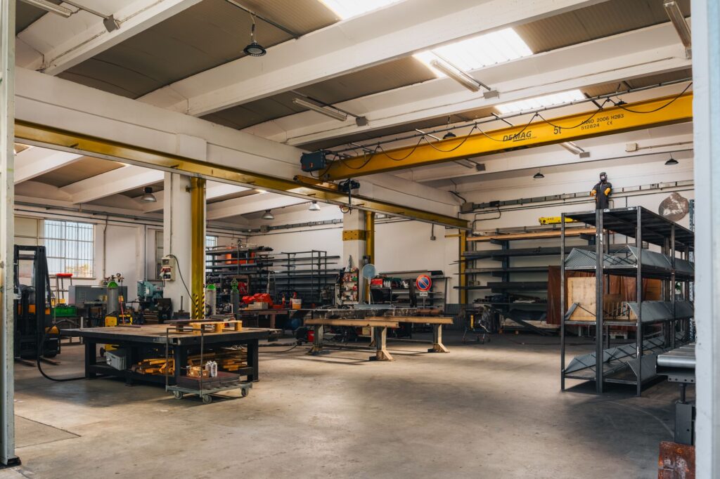Interno dell'officina di carpenteria in ferro con carroponte e banchi di lavoro
